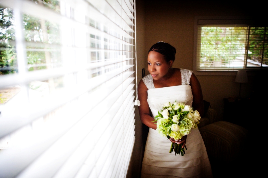 bride looks out the window of her home before her wedding