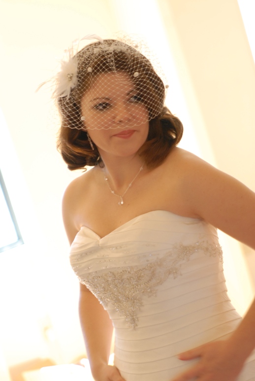 bride looking in the mirror, wearing a bird cage veil