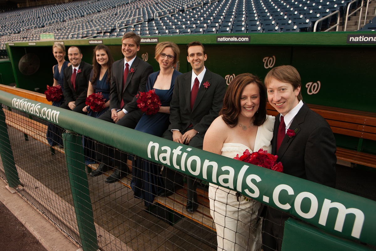 wedding party portrait sit on the bench in the dugout