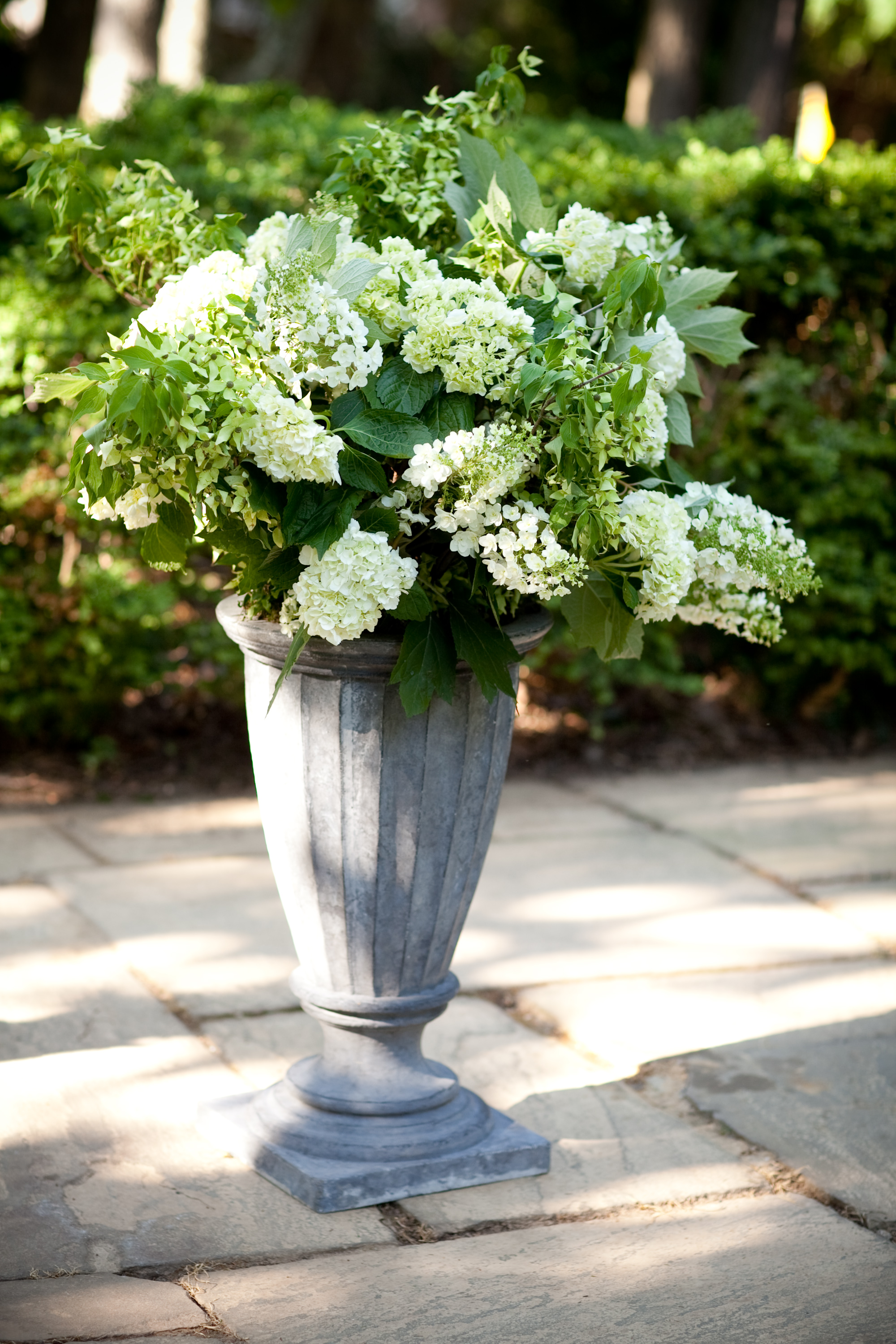 white and green flowers in a large urn for the ceremony area
