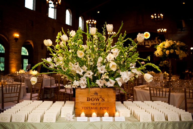 escort card table with a large flower arrangement built in a vintage port wine box