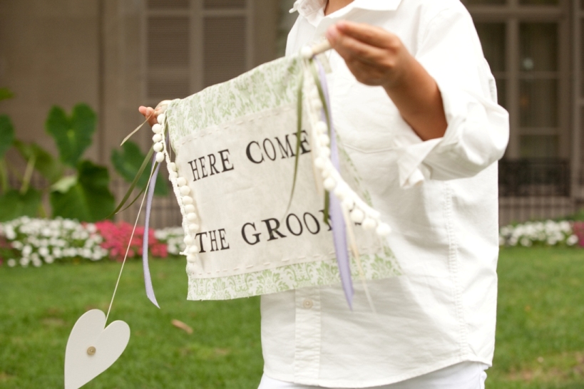 "here come the grooms" sign bearer and son of the grooms