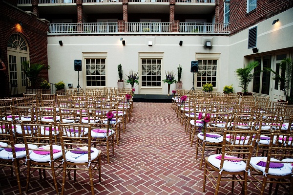 gold chivaris with purple and pink fans are set in the hotel courtyard