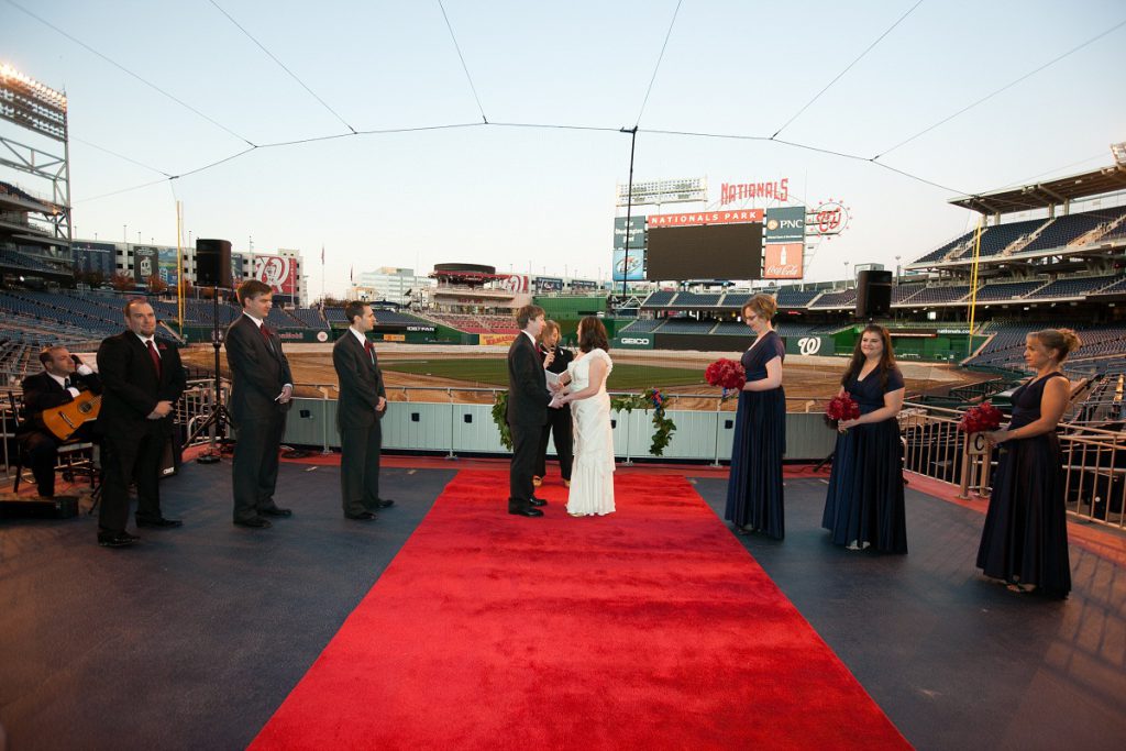 Nationals Park wedding - The bride and groom marry behind home plate at the end of a red carpet runner
