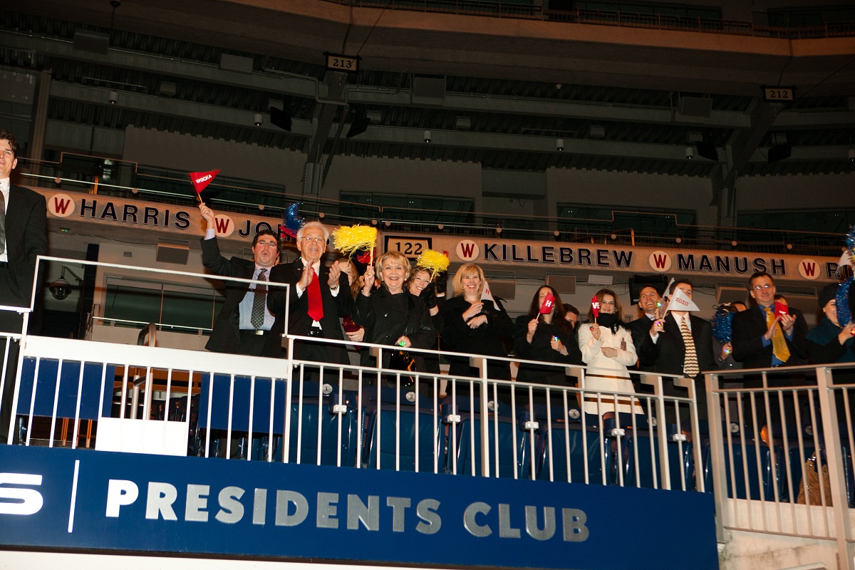 guests cheer and wave pom poms and pennant flags from the stands at the end of the ceremony