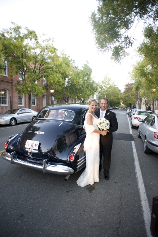 bride and groom pose by the cadillac