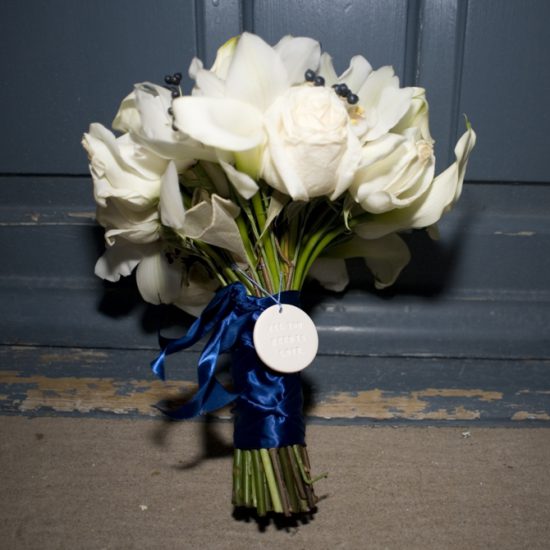 bride's white bouquet with navy ribbon