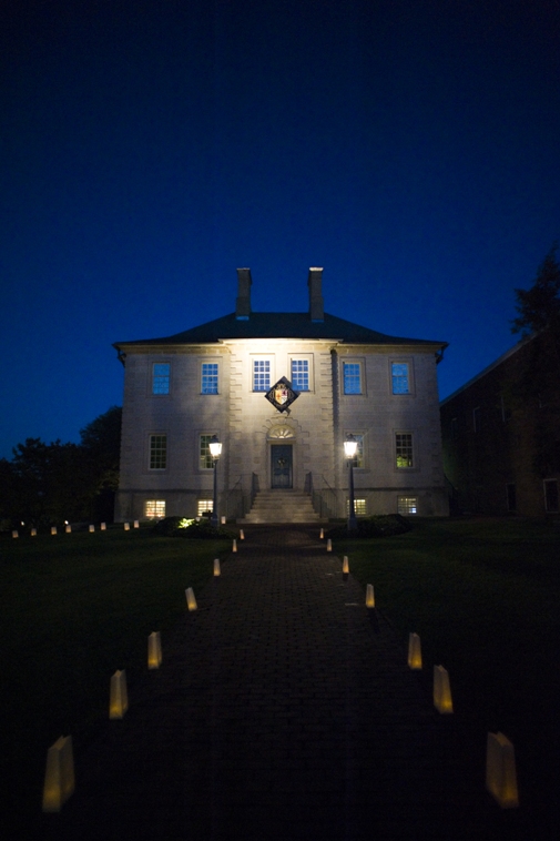 nighttime photo of Carlyle house with luminaries lining the sidewalks