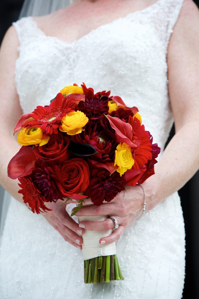 A red, burgundy and mango bridal bouquet