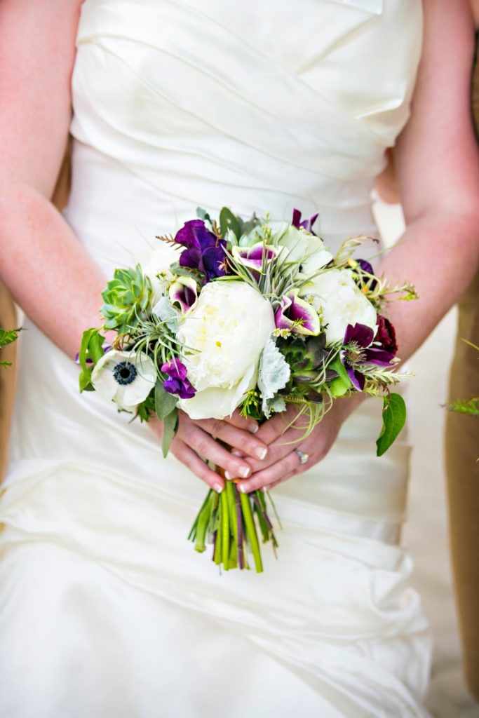 A petite white and purple bridal bouquet