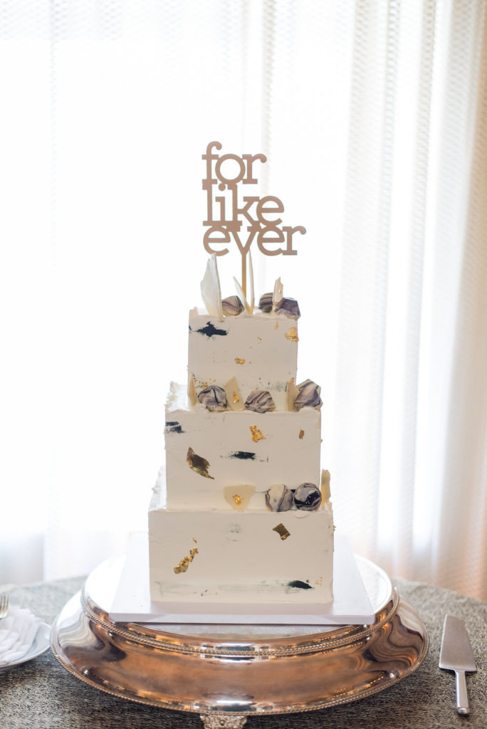 White buttercream wedding cake with black and gold accents