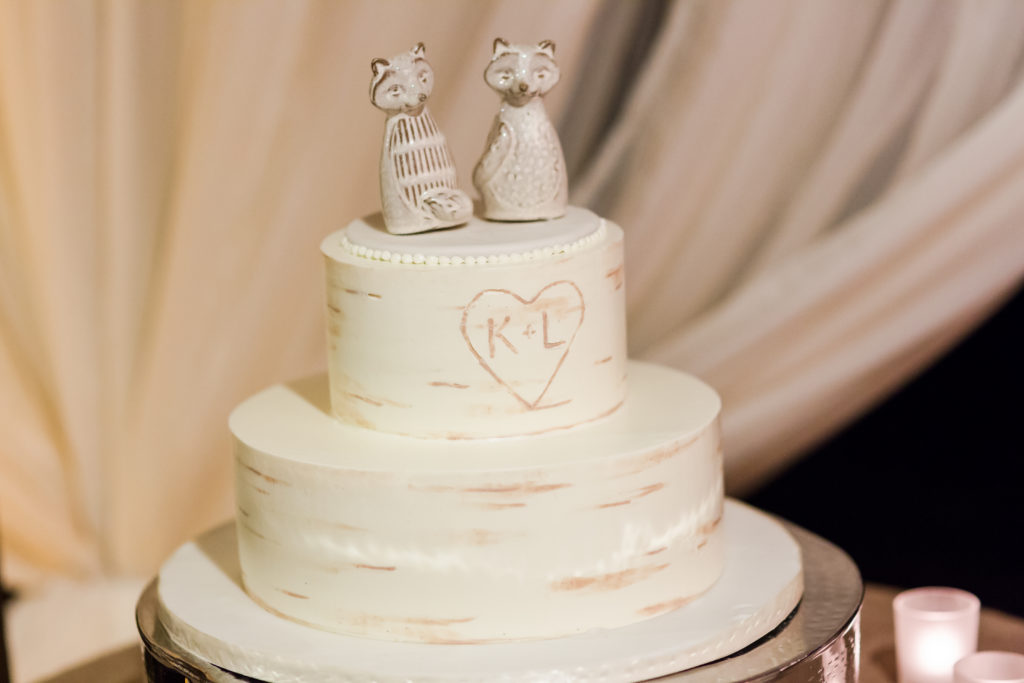 White buttercream wedding cake with woodgrain and foxes