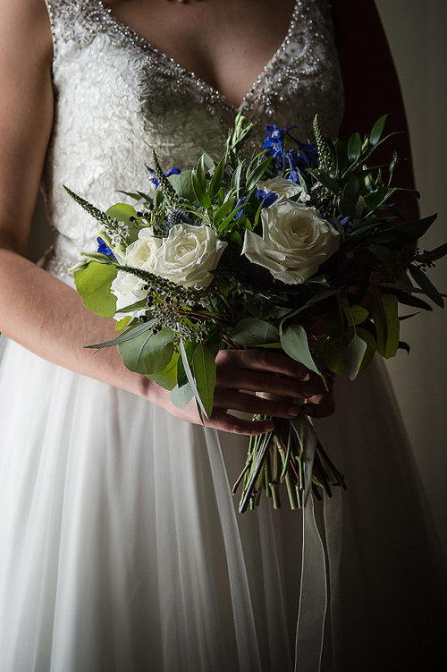 A white bridal bouquet with blue accents