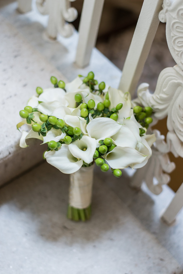 A bridal bouquet of white calla lilies and green berries 