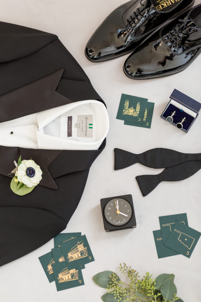 groom's attire black tux and accessories flat lay