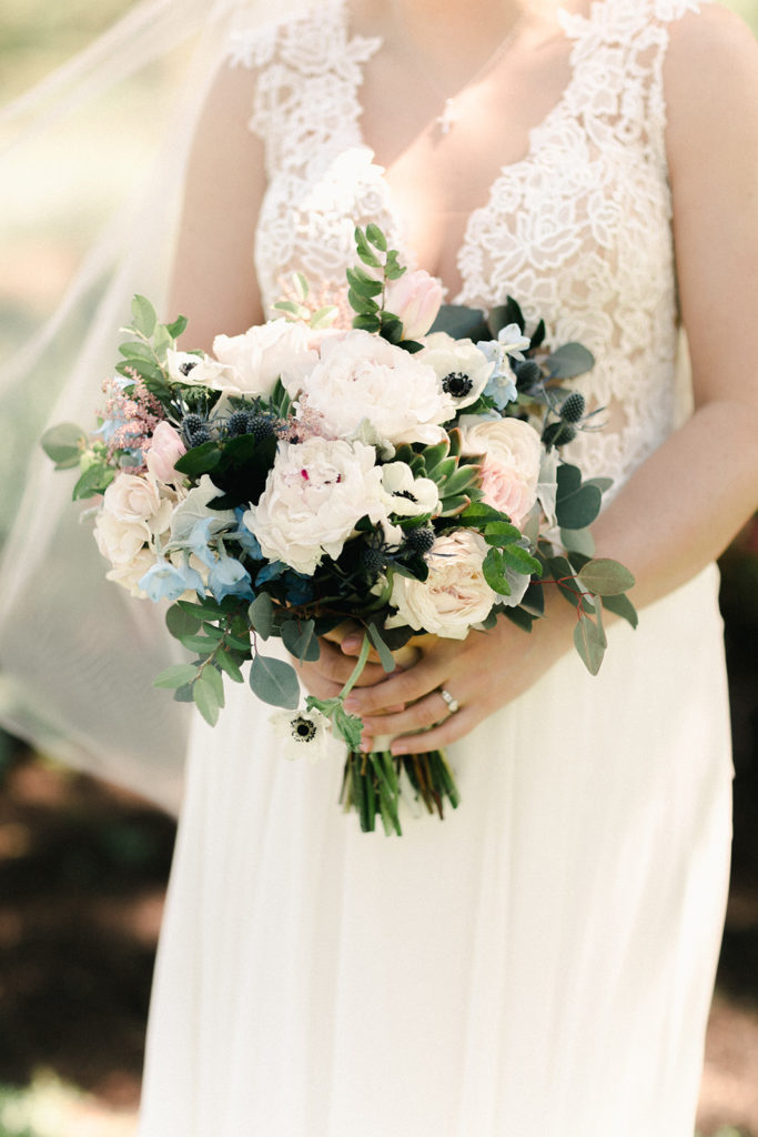 A white bouquet with pastel accents and greenery
