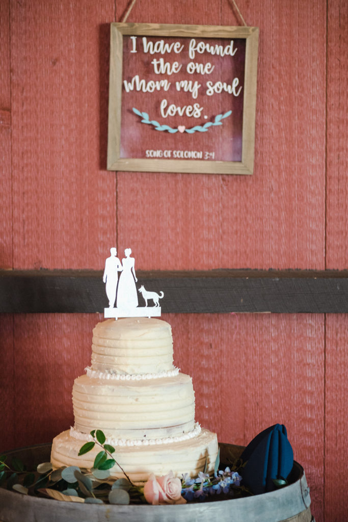 white buttercream wedding cake with custom cake topper