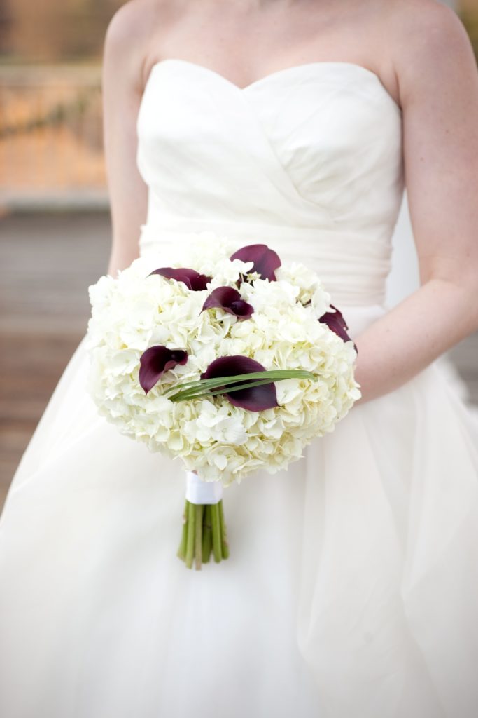 a bridal bouquet with white hydrangea and aubergine mini calla lilies 