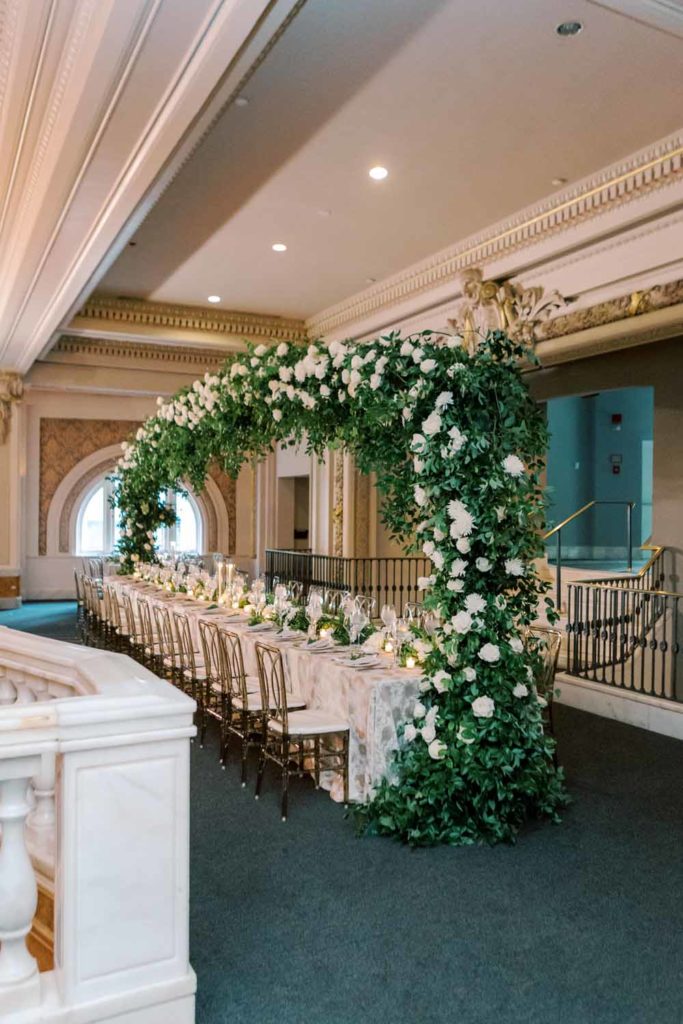 giant head table greenery arch white flowers