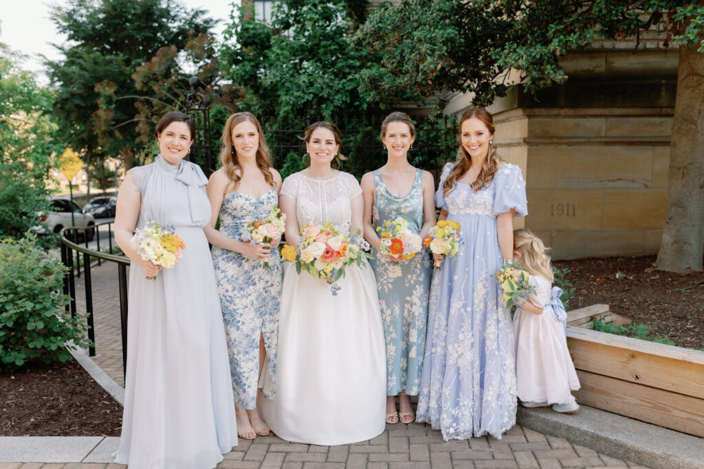 bridesmaids in mismatched, blue, floral dresses