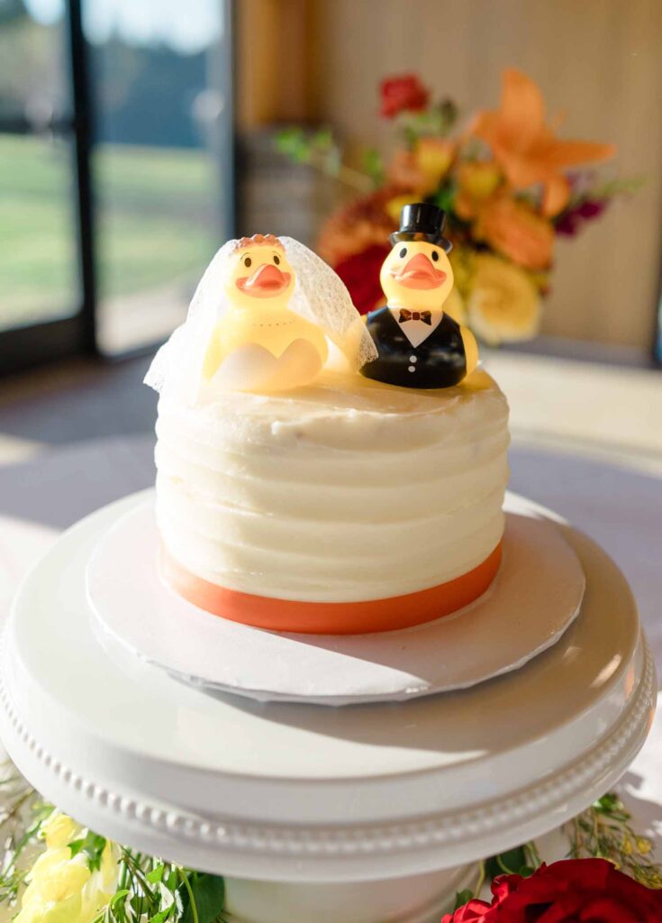 white buttercream wedding cake cutting cake with rubber duckie bride and groom topper