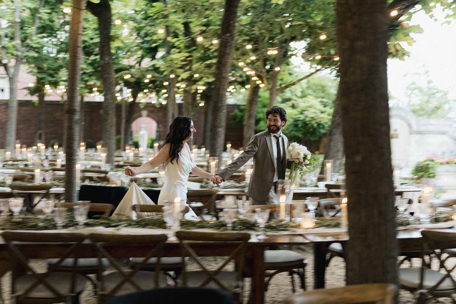 bride and groom walk amongst al fresco long wedding tables in Linden Grove at Meridian House